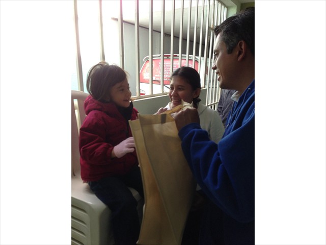 Edwin giving a child in need items that will help her while having her much needed surgery.