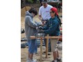 Edward, Jess, and Lars making a assemble line creating the rebar with pliers and wire in order to make the posts to hold the cement for the children's hospice foundation, one by one.