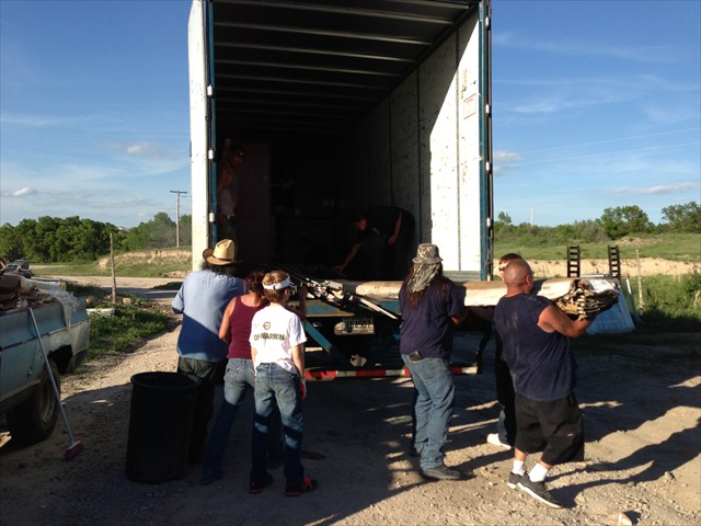 Everyone helped to offload our Lakota trailer filled with siding for our Sacred Lakota Home.
