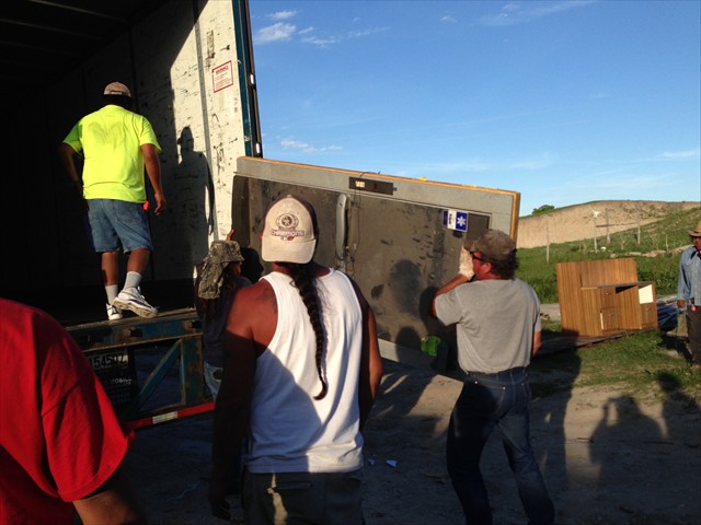 Offloading a donated walk in cooler for when the men go hunting for food.