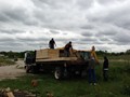 Offloading by hand the building material for the Camp Home.