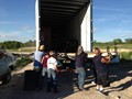 Everyone helped to offload our Lakota trailer filled with siding for our Sacred Lakota Home.